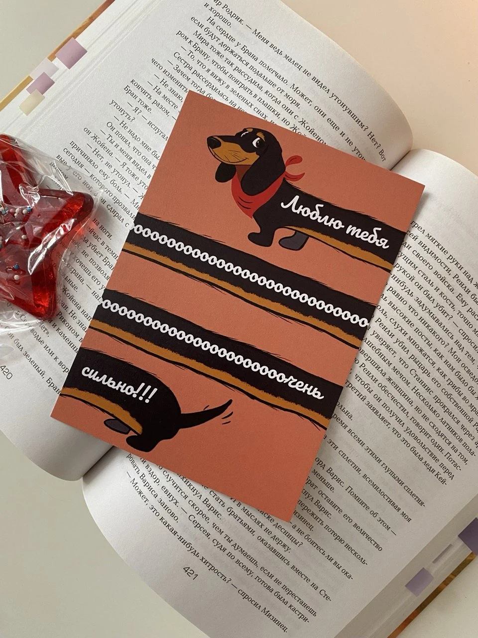 Открытка с таксой «Люблю тебя сильно» на раскрытой книге